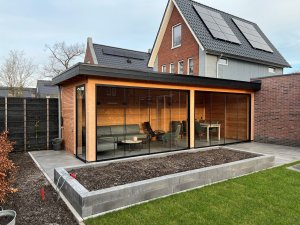 Moderne tuin met overkapping van douglas hout bruin en zwart met Fiano glazen schuifwanden