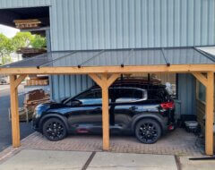 carport van hout met zonnepanelen met auto eronder
