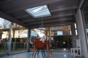 Uitbouw aan huis met schuifpui wit en lessenaarsdak lichtstraat